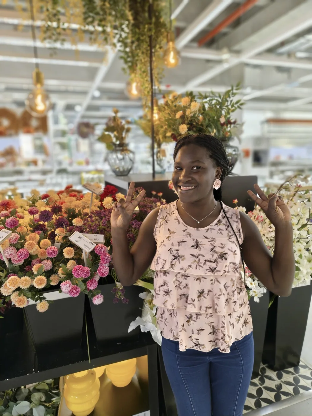 Paula smiling in front of colourful flowers